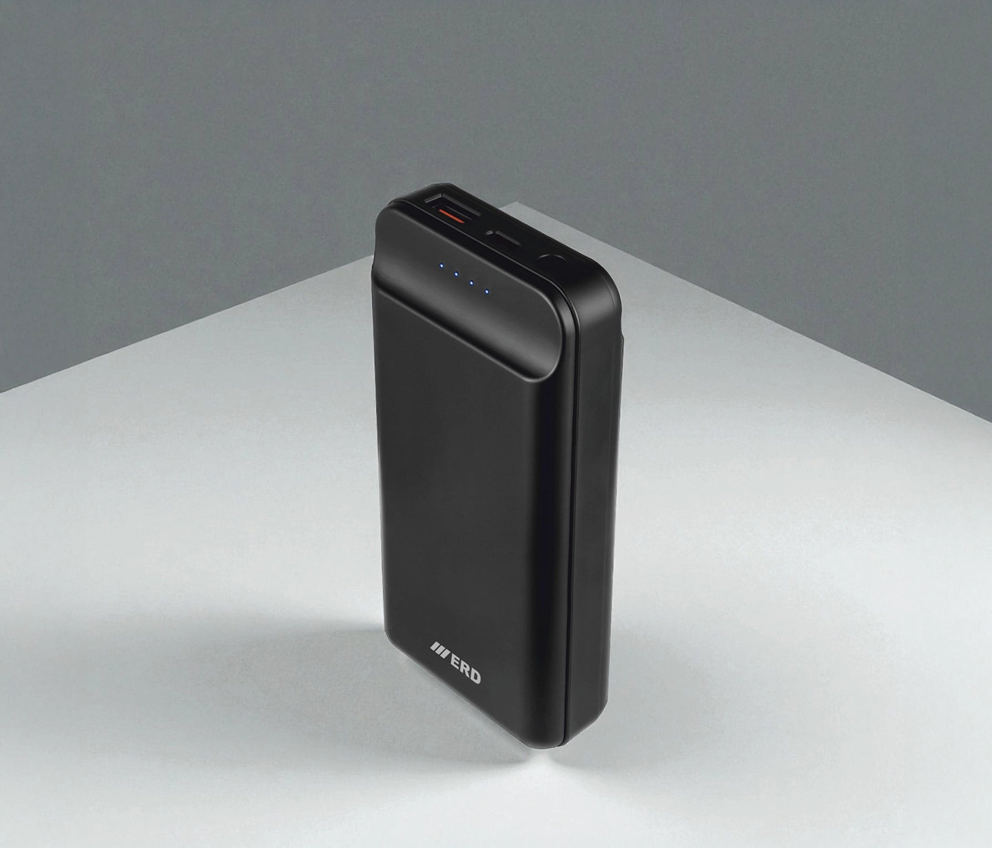 Black power bank on a gray surface with a gray background